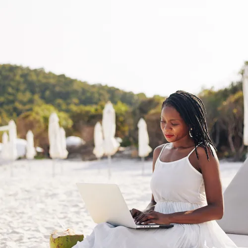 femme reservant un vtc a la reunion en ligne depuis son ordinateur en bord de plage